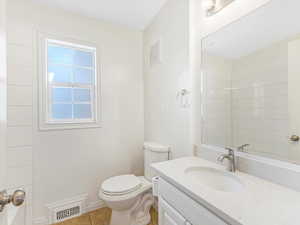 Bathroom featuring tile patterned flooring, vanity, and toilet