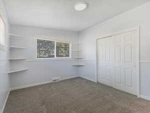 Unfurnished bedroom featuring a closet and carpet flooring