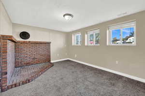 Unfurnished living room with a textured ceiling and carpet