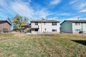 Back of property with a wooden deck and a lawn