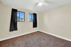 Carpeted spare room with ceiling fan