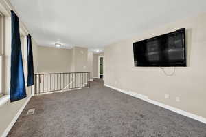 Unfurnished room with carpet flooring and a textured ceiling