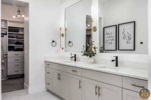 Bathroom featuring vanity, a chandelier, and tile patterned floors