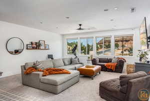 Living room featuring carpet floors, a textured ceiling, and ceiling fan