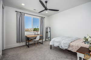 Carpeted bedroom featuring ceiling fan