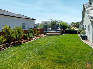 View of yard featuring a trampoline and central AC unit