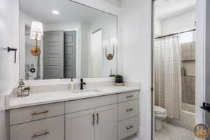 Full bathroom featuring vanity, tile patterned floors, toilet, and shower / tub combo with curtain