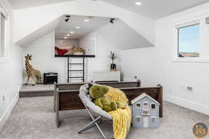 Office space with lofted ceiling, wood walls, and light carpet