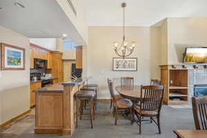 Dining area with sink, a chandelier, and a tile fireplace