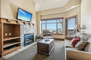 Carpeted living room featuring a tile fireplace