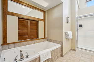 Bathroom with independent shower and bath and tile patterned flooring