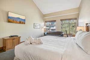 Bedroom with high vaulted ceiling and carpet flooring