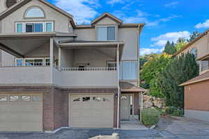 View of front of house featuring a balcony and a garage