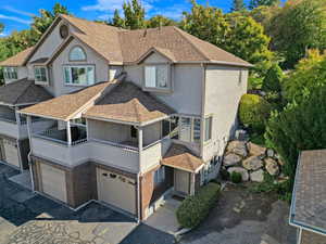 View of front of home featuring a balcony and a garage and single parking space next to home