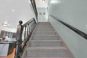 Stairs featuring a textured ceiling and hardwood / wood-style flooring