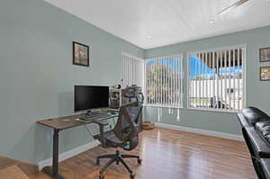 Office space with a textured ceiling and hardwood / wood-style flooring