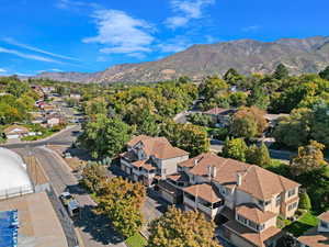 Birds eye view of property with a mountain view mature trees