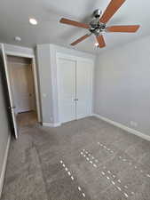 Unfurnished bedroom with carpet flooring, ceiling fan, and a closet