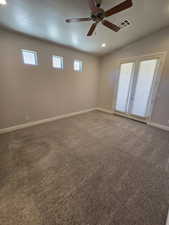 Unfurnished room with a textured ceiling, carpet, vaulted ceiling, and ceiling fan