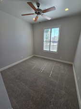 Carpeted spare room featuring ceiling fan