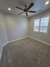 Carpeted empty room featuring ceiling fan