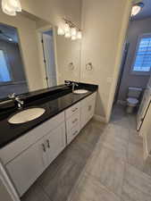 Bathroom with vanity, toilet, and tile patterned floors