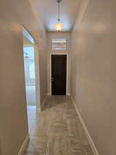 Doorway to outside with a textured ceiling, light tile patterned floors, and ceiling fan