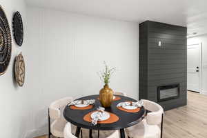 Dining room featuring light wood-type flooring and a large fireplace