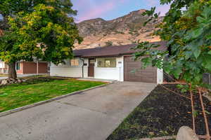 Single story home featuring a mountain view, a yard, and a garage