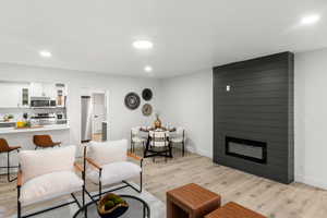 Living room with light wood-type flooring and a large fireplace