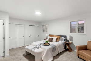 Carpeted bedroom featuring multiple closets