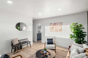 Living room with light hardwood / wood-style flooring and sink