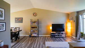 Living room with a textured, vaulted ceiling, new LVP flooring, and ceiling fan