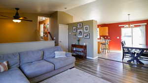 Living room with a textured ceiling, lofted ceiling, new LVP flooring, and ceiling fan