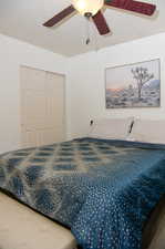 Bedroom featuring one of two closets in the room and ceiling fan