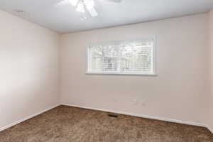 Unfurnished room featuring ceiling fan and carpet floors