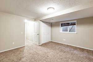 Basement with carpet flooring and a textured ceiling