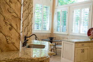 Kitchen featuring light stone counters and plenty of natural light