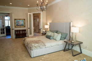 Bedroom featuring ornamental molding, a chandelier, and carpet flooring