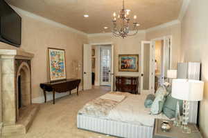 Bedroom with crown molding, an inviting chandelier, and light carpet