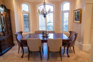 Dining room featuring crown molding, a chandelier, and a healthy amount of sunlight