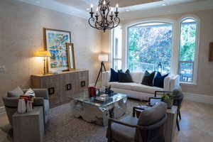 Living room featuring a notable chandelier and crown molding