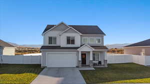 View of front of house featuring a front yard, a mountain view, and a garage