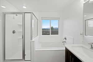 Bathroom featuring vanity and plus walk in shower