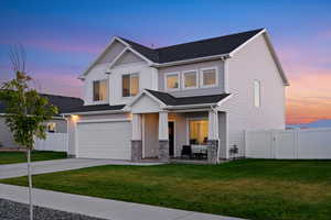 View of front facade with a lawn and a garage