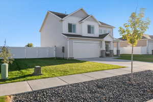 View of front of house featuring a garage and a front lawn