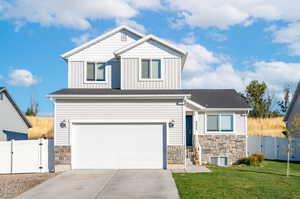 Craftsman-style home featuring a front yard, cooling unit, and a garage