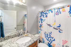 Bathroom featuring vanity, toilet, and a shower with shower curtain