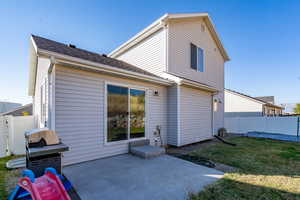 Back of property featuring a lawn and a patio