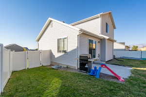 Rear view of house with a lawn and a patio area